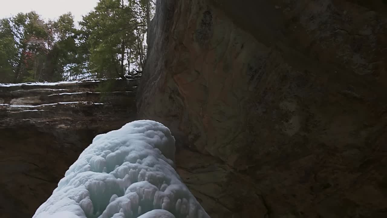 goteo de agua a los carámbanos hasta el cono de hielo en la cueva de cenizas, ohio, ee.uu.