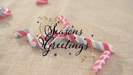 animation of seasons greetings text over candy canes