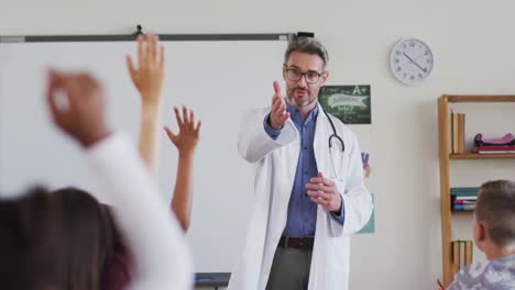 Trabajador-Médico-Caucásico-Usando-Estetoscopio,-De-Pie-En-El-Aula-Haciendo-Preguntas