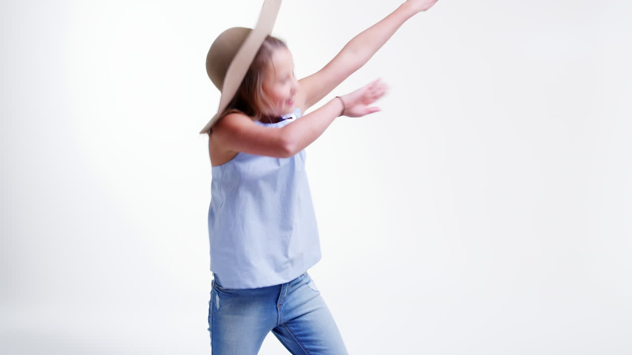 Garota usando chapéu fazendo pose dab contra fundo de estúdio branco