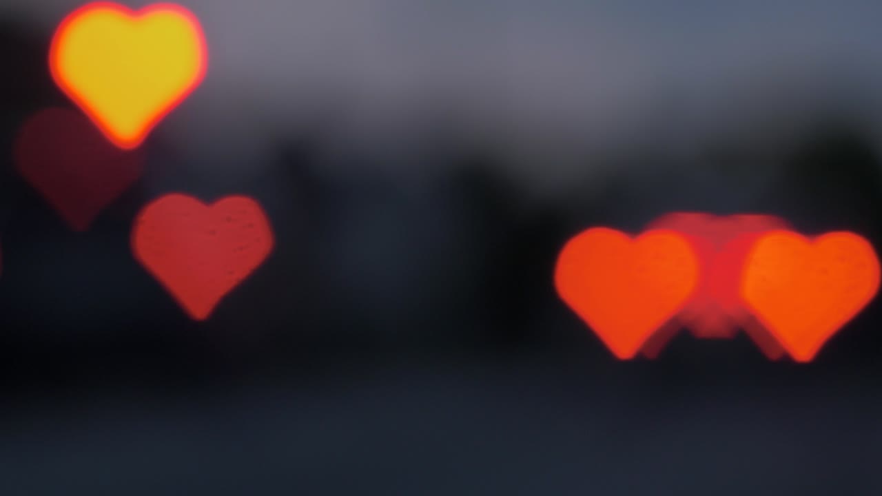 저녁, 발렌타인 데이 또는 배경 개념과 같은 소셜 미디어에서 움직이는 자동차와 신호등에서 아름다운 하트 보케