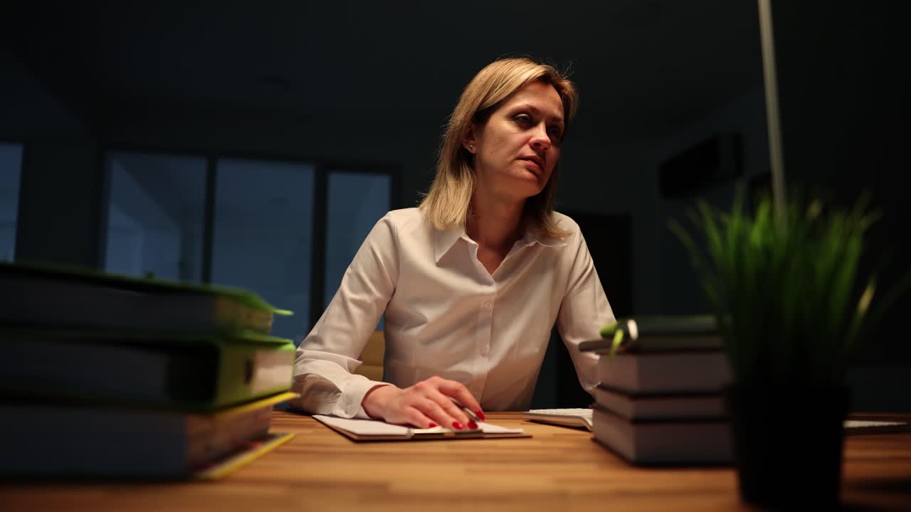 Donna d'affari stanca alla sua scrivania