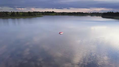 family on a pedal boat on a lake drone footage