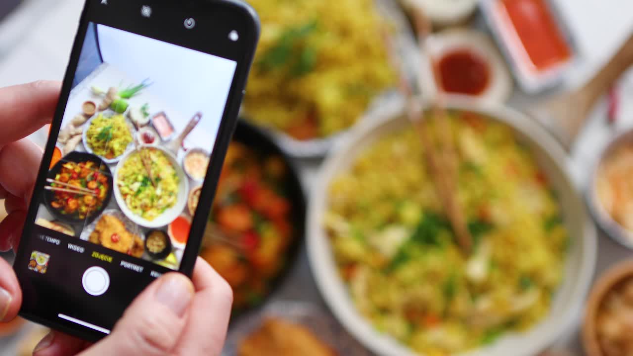mujer tomando una foto con su teléfono inteligente listo para el concepto de comida asiática en las redes sociales