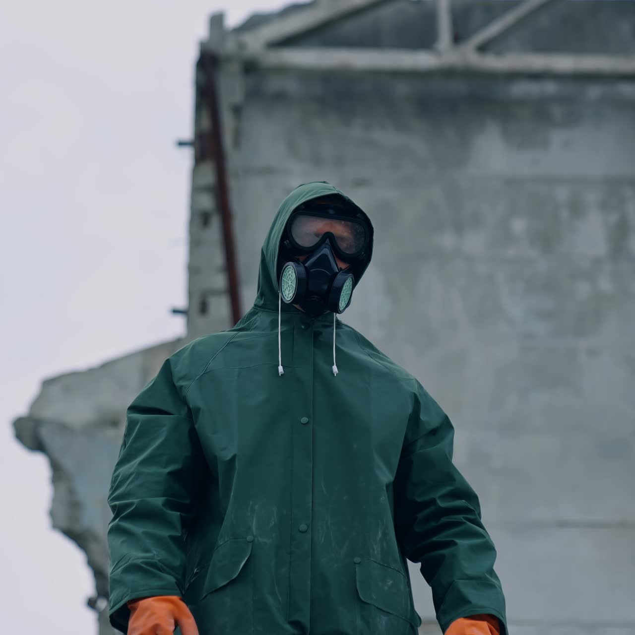 Man in gas mask on destroyed building background. Survivor in respirator and safety suit standing in radioactive zone. Ecological catastrophe. Post apocalyptic world