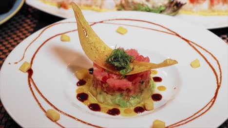 close up appetizer plate of tuna tartar with plantains on the table in a luxury restaurant