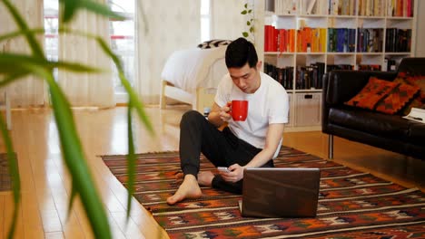 Man-using-mobile-phone-in-living-room