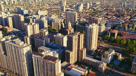 vuelo de drones sobre el horizonte de santiago hacia la iglesia de sacramento, chile