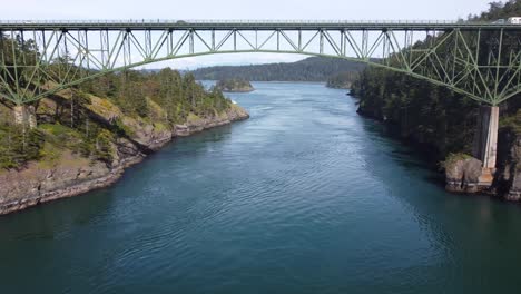 drone cinematográfico disparó volar bajo el puente de paso de engaño en anacortes, washington, ee.uu. en un día soleado de primavera
