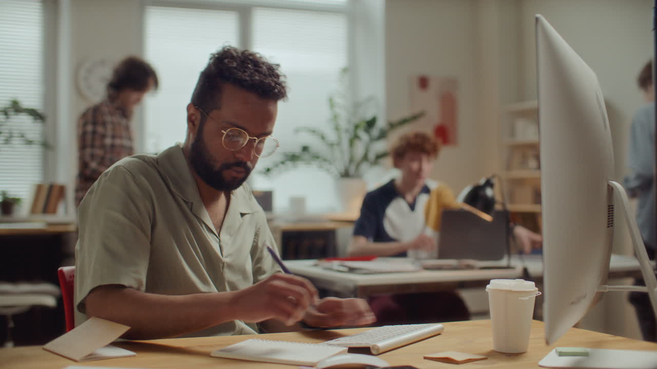Time Lapse of Man Working on Computer and Writing Notes at Desk in Office