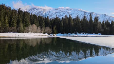 Spiegelung-Der-Schweizer-Alpen-In-Einem-Ruhigen,-Halb-Zugefrorenen-See-Lac-Des-Mines-D&#39;Or