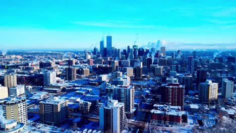 buttery smooth aerial reverse flyover downtown capitol city of edmonton from north east to north west snow covered buildings are steaming thru chimney's during extreme cold weather skyline view2-2