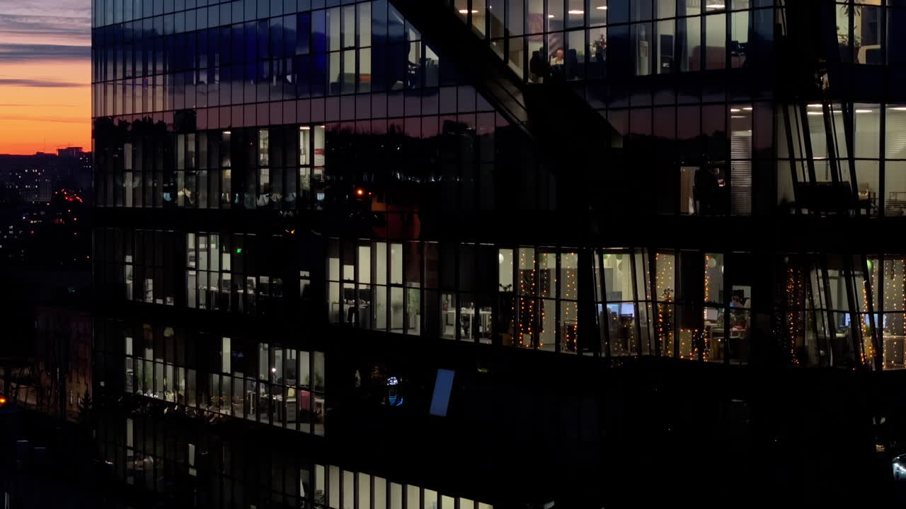 Aerial drone view of a glass building in Chisinau, Moldova at sunset, people working at business office