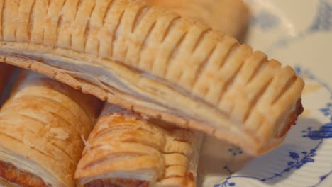 collection of sausage rolls lying on plate. delicious traditional english fresh bakery product. british snack cuisine. pork meat wrapped in puff pastry.
