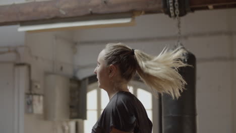 Side-view-of-Caucasian-woman--doing-jumping-jacks-in-gym