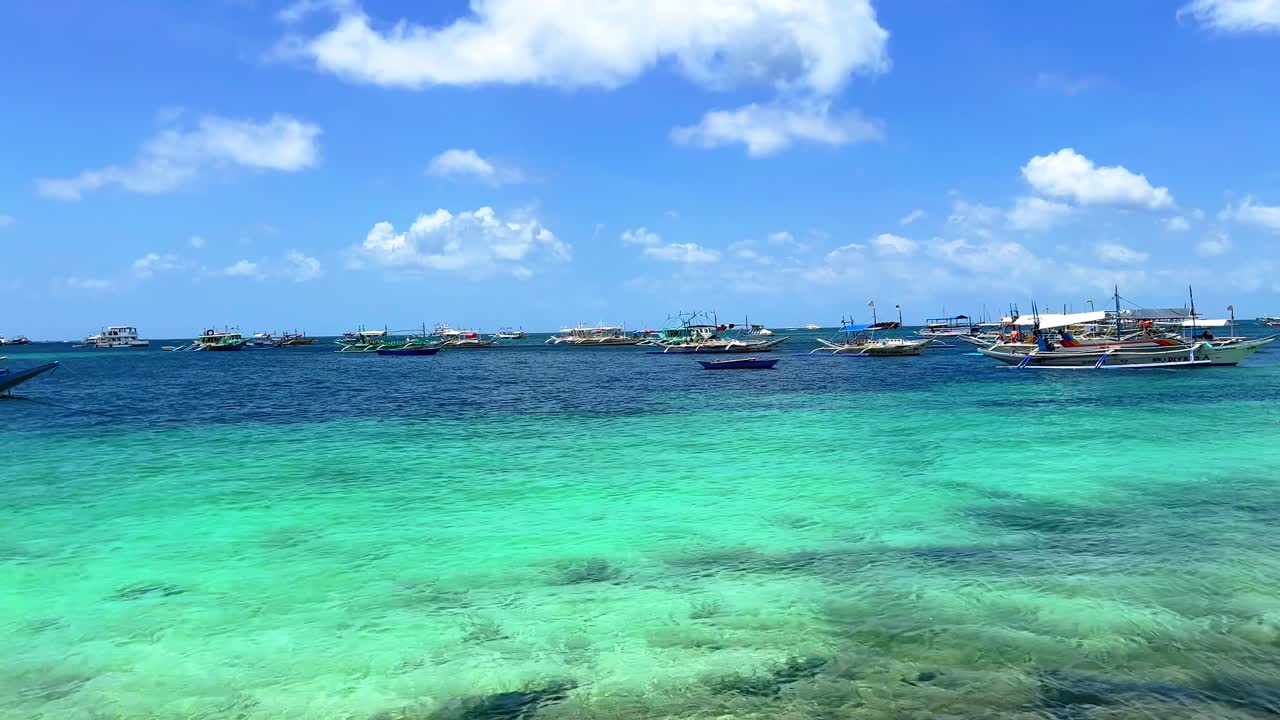 Crystal-clear turquoise waters and traditional boats create a dreamy tropical seascape perfect for travel and tourism content