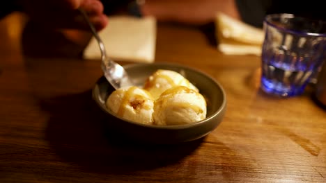 person enjoying ice cream dessert at a table