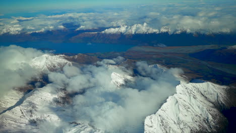 south island queenstown new zealand snowy mountain peaks aerial drone flight high altitude winter cloudy beautiful sunny morning afternoon lake wanaka wakatipu landscape circle to the left movement