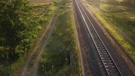 Sunset green forest hill and mountain rural village landscape perspective by parallel railway varnished iron steel transportation line rain trip passenger in Iran rice paddy nature scenic gilan view