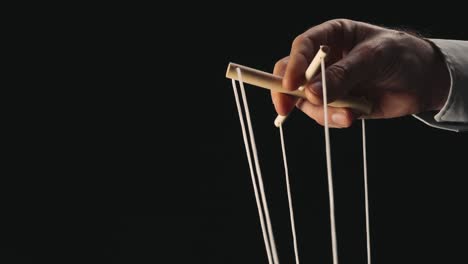 Hand pulling strings of a puppet