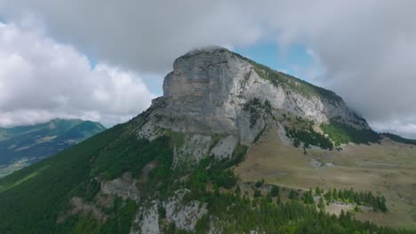 Circular-shot-approaching-mountain,-with-pine-valley-and-clouds,-Mount-Granier