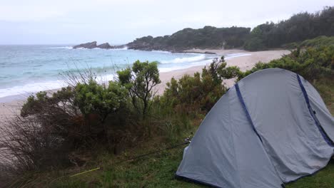 una carpa montada en una playa en la costa sur de nueva gales del sur en un clima lluvioso y tormentoso