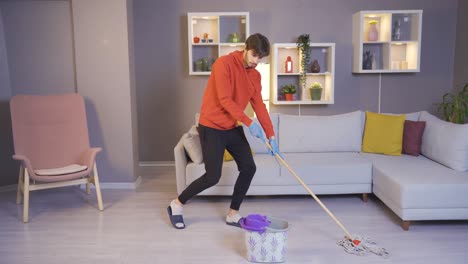 Happy-dancing-singing-young-man-cleaning-house.