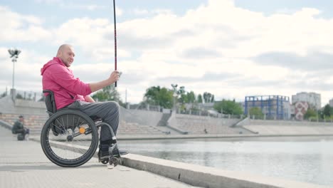 persona con discapacidad física que utiliza silla de ruedas para pescar en el muelle de pesca