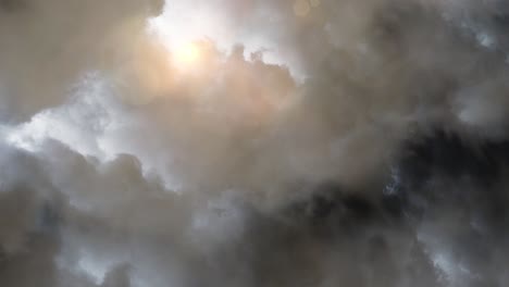 sunshine behind dark clouds with lightning strike