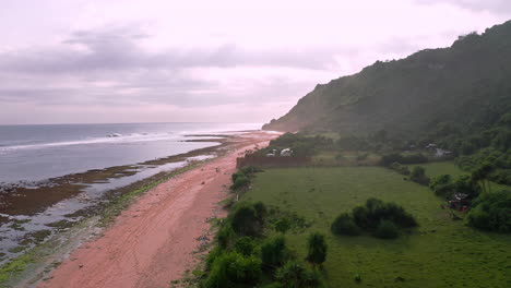 Coastal-homesteads-on-beach-at-low-tide,-humid-sea-spray-in-air