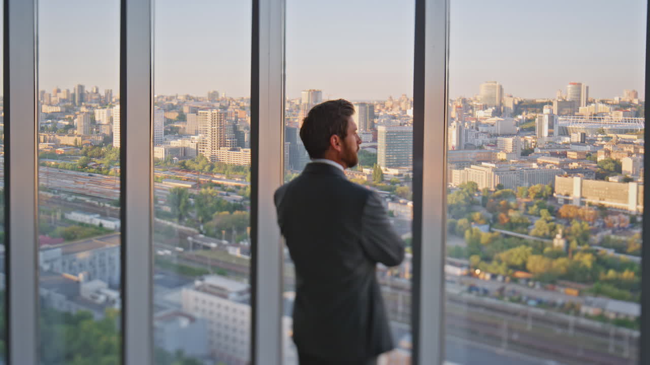 ejecutivo elegante mirando por la ventana vista trasera. empresario pensativo admirando la ciudad