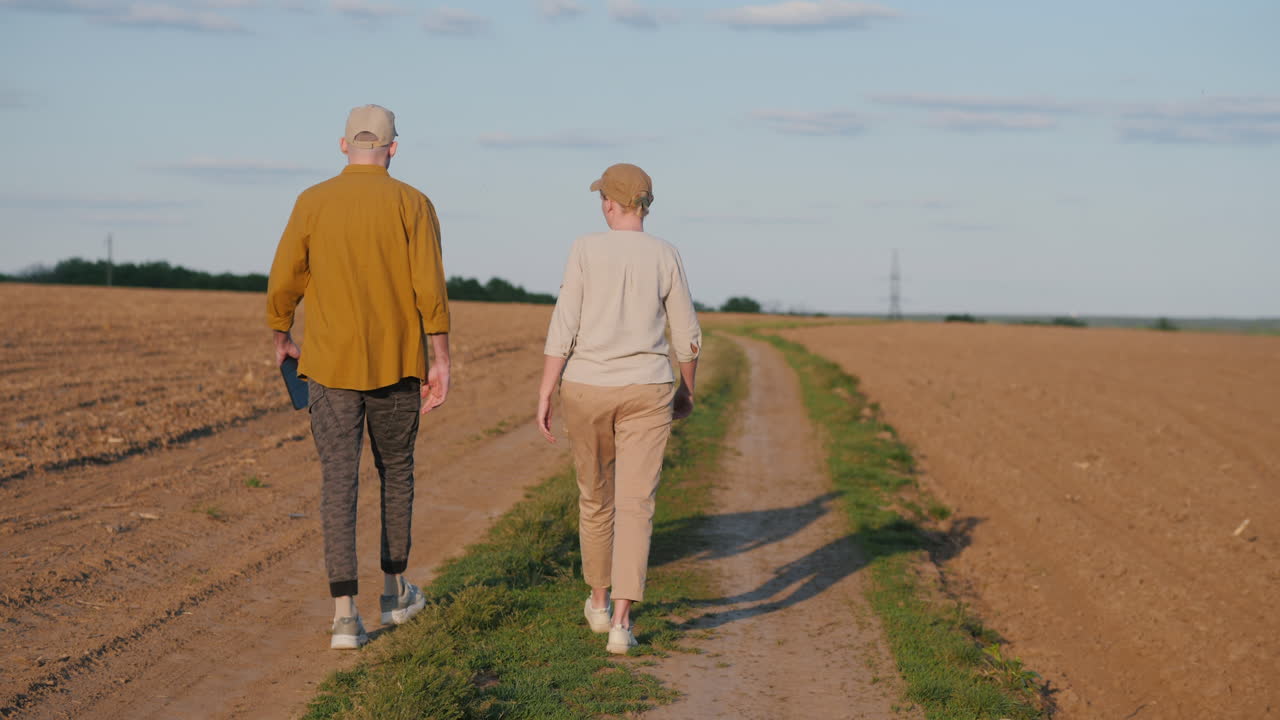 una pareja caminando por un campo.