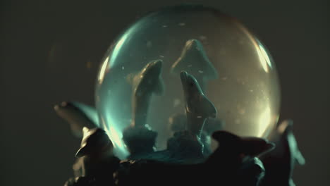 dolphin figurines are inside a snow globe