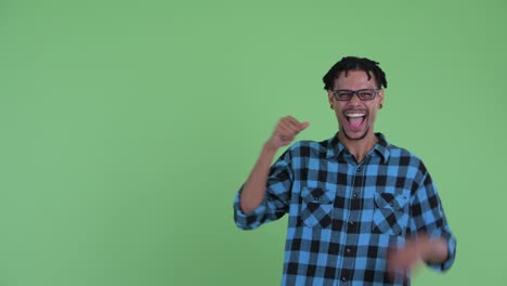 joven feliz y guapo hombre hipster africano mostrando algo