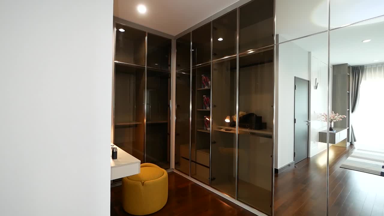 Design d'interni lussuoso ed elegante per una cabina armadio compatta in camera da letto.