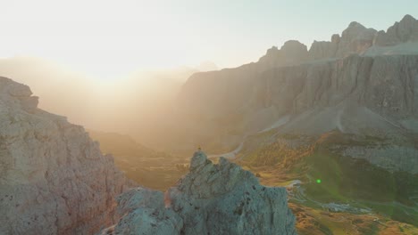 a solitary individual on piccola cir witnesses dawn's embrace, as the sun illuminates the vast dolomites' expanse