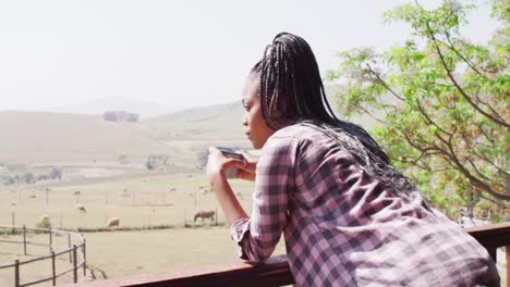 thoughtful african american woman drinking coffee in log cabin, slow motion