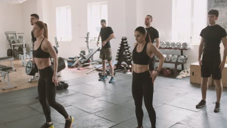 a group of young men and women do stretching exercises in the gymnasium