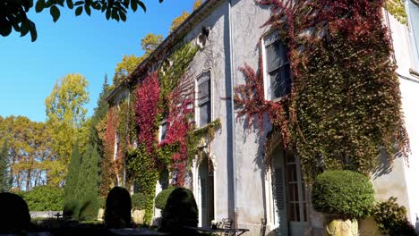 Slow-panning-shot-of-a-castle-in-the-French-countryside-being-invaded-by-colorful-ivy