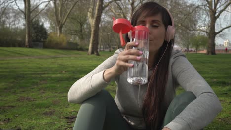 caucasian female drinking water in a park