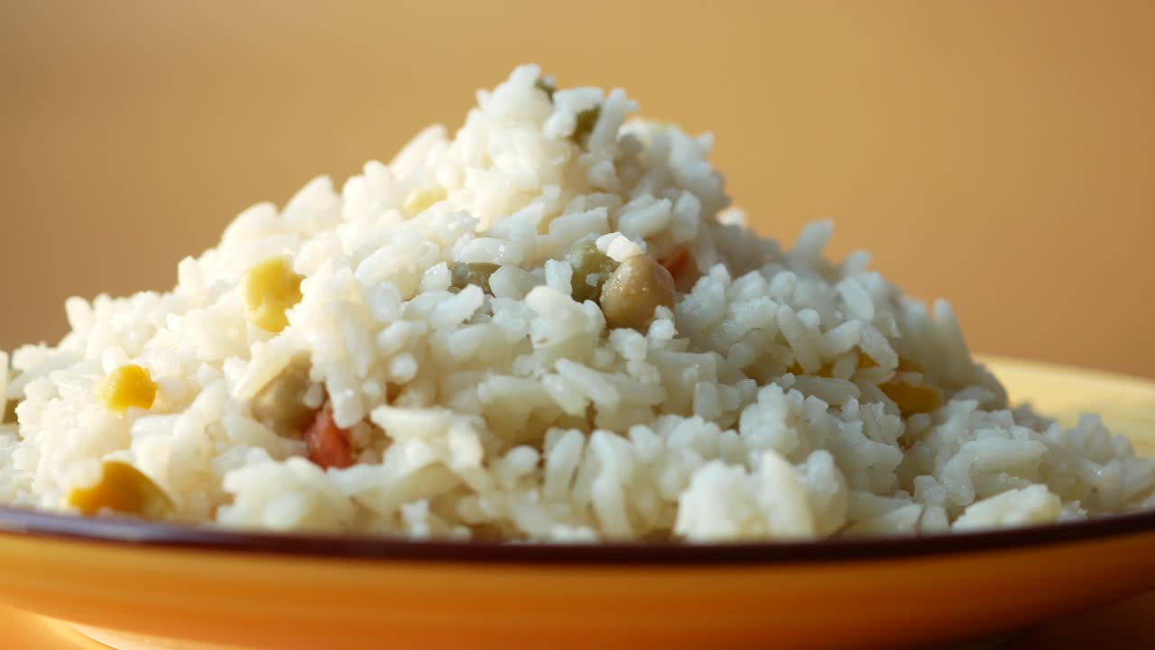 arroz blanco con verduras en un plato amarillo