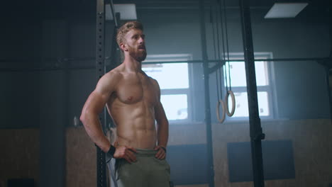 He-already-looking-for-the-next-challenge.-Tired-muscle-athlete.-Tired-man-having-rest-after-workout.-Tired-and-exhausted-male-athlete-sitting-on-floor-at-gym-with-a-water-bottle.