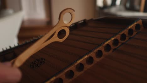 primer plano de instrumento clásico de cuerda de dulcimer de madera, palos de madera martillando para melodía y sonidos armónicos