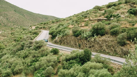 Car-driving-up-a-swirvy-road-in-the-mountains