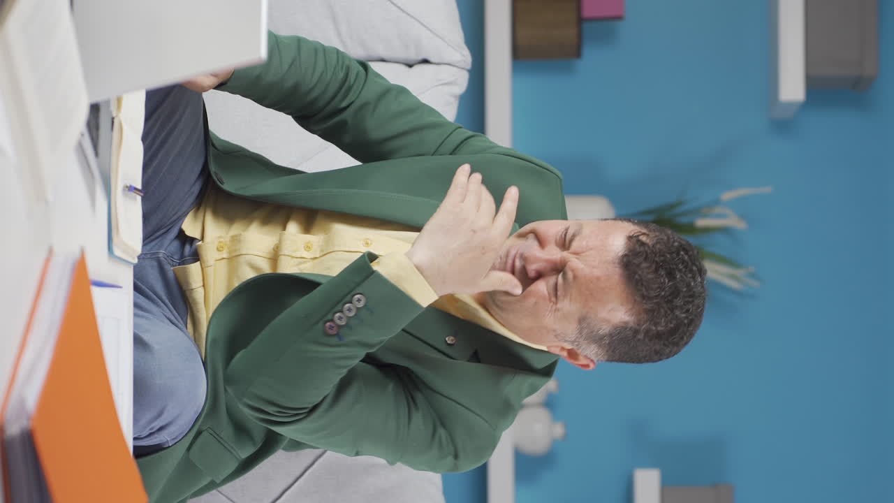 vídeo vertical de un anciano trabajador de oficina en casa viendo su fracaso en la computadora portátil.