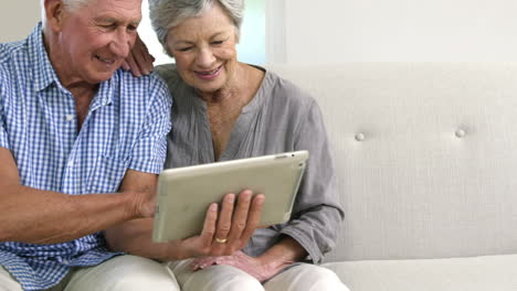 happy senior couple using tablet