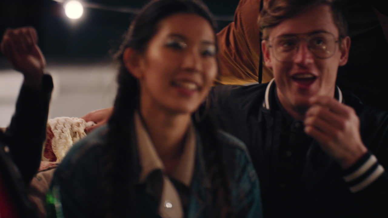 행복한 옥상 파티 친구들이 주말에 즐거움을 즐기고 소파에 앉아 대화를 나누고 활기찬 음악을 즐기고 밤에 함께 놀고 있습니다.