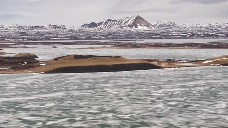 frozen lake mývatn with skútustaðagígar rootless cones and snow-covered peaks. reykjahlíð, iceland