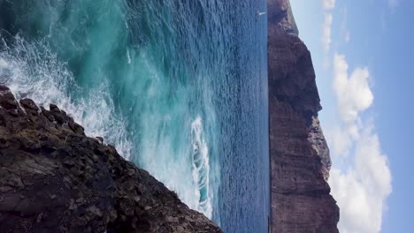 antena vertical de la costa con aguas cristalinas azules del océano que se estrellan en la costa