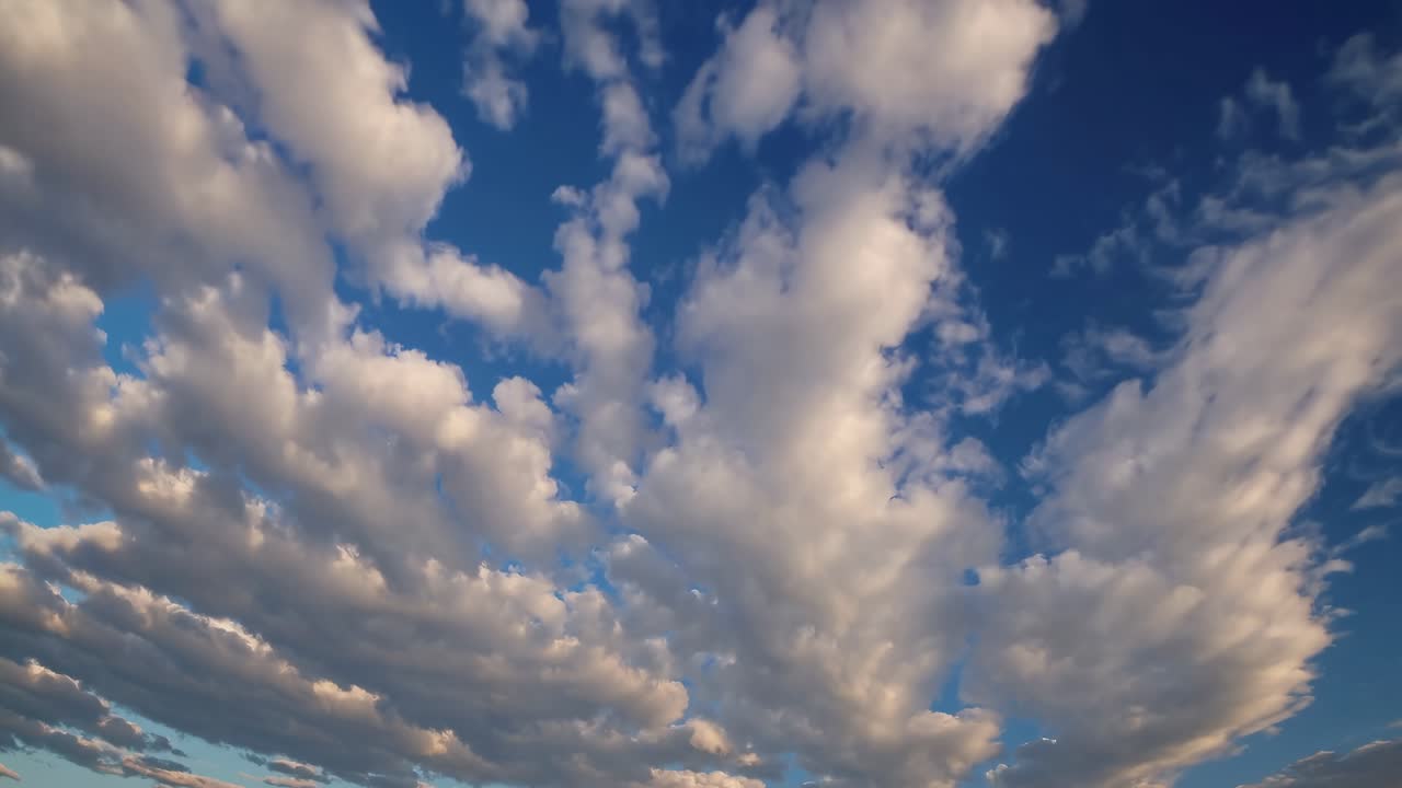 A serene wide-angle video shot of a vibrant blue sky with scattered white clouds